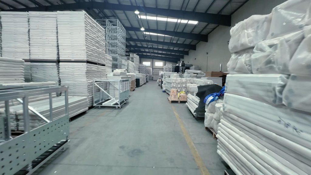 Indoor warehouse storage of aluminum spigot truss, stage decks, and export-ready PE wrapped stage equipment for overseas shipment