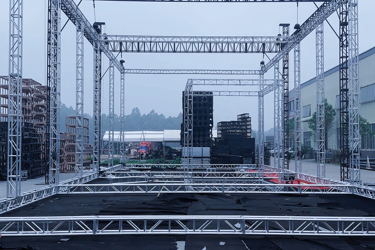 Large outdoor stage truss structure with electric hoist lifting system and reinforced support framework during construction