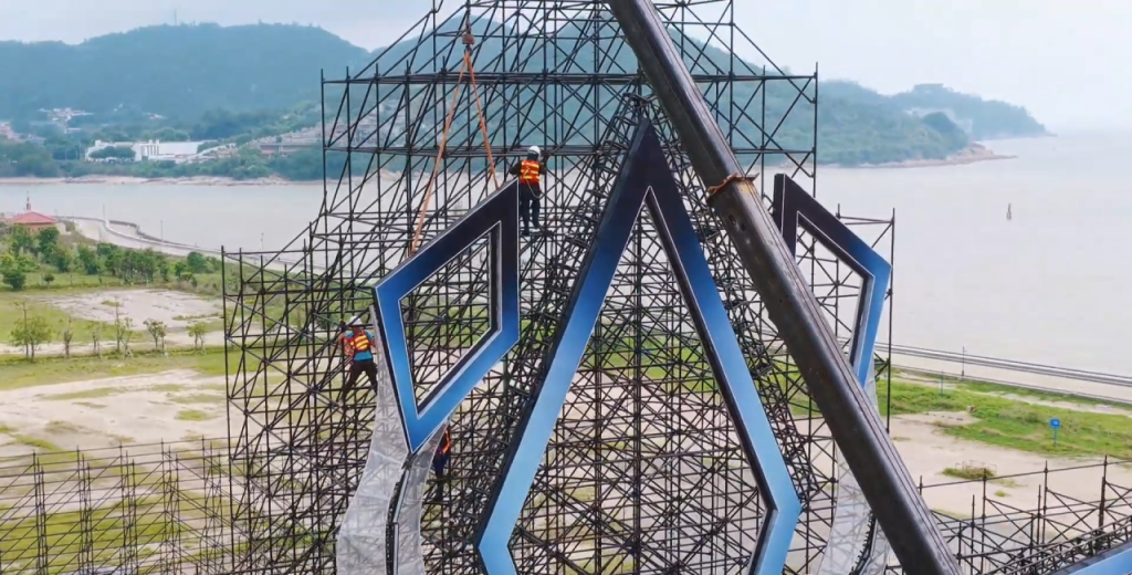 Workers assembling Ringlock scaffolding stage structure at VAC Music Festival, showing team installation and structural framework