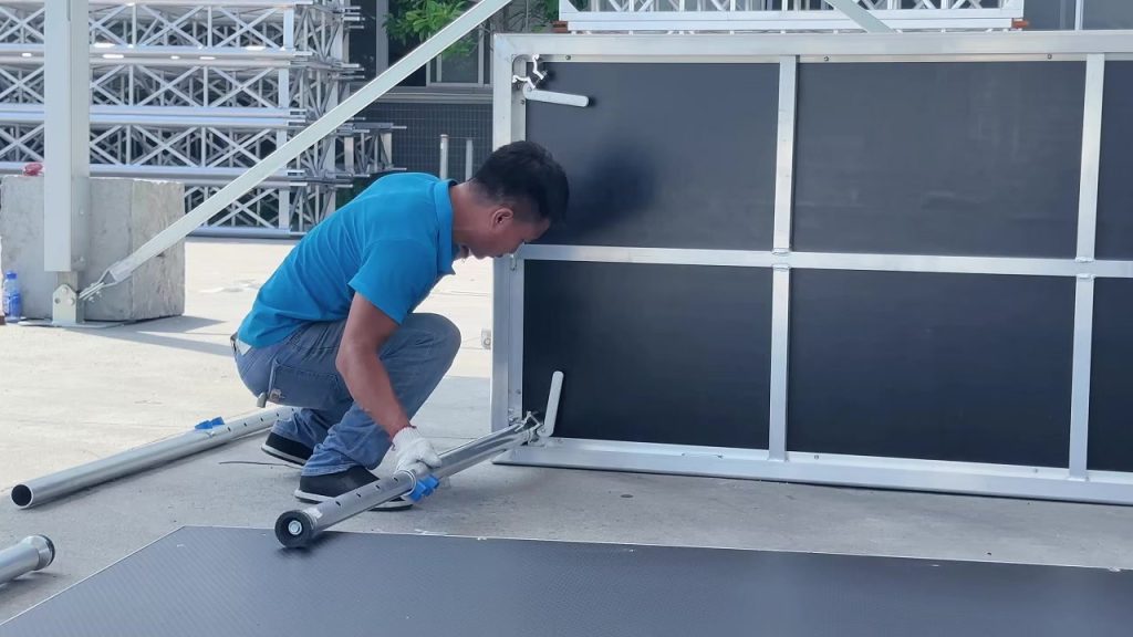 Installing support legs on aluminum portable stage deck