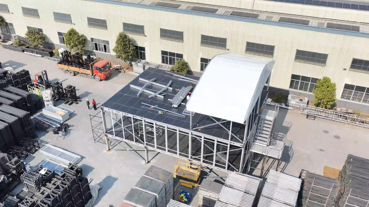 Three-tier event grandstand factory test assembly with roof canopy and stair access